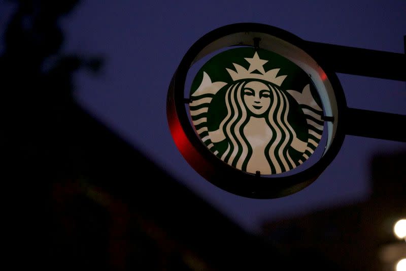 FILE PHOTO: Traffic lights illuminate a Starbucks sign before the 5am opening of a Center City Starbucks, where two black men were arrested, in Philadelphia, Pennsylvania