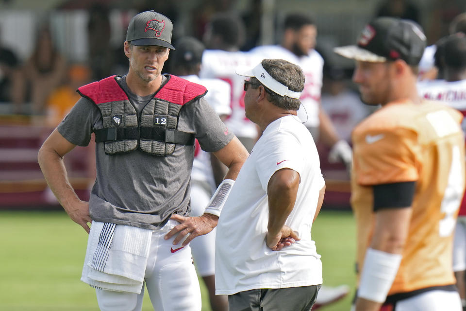 Tampa Bay Buccaneers quarterback Tom Brady (12) talks to coach Clyde Christensen during an NFL football training camp practice with the Miami Dolphins Wednesday, Aug. 10, 2022, in Tampa, Fla. (AP Photo/Chris O'Meara)