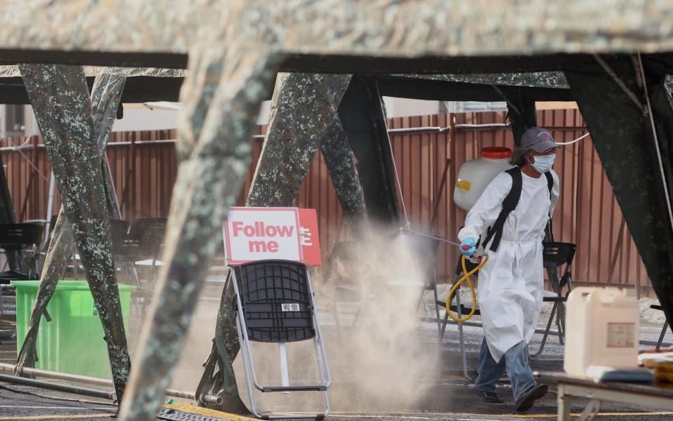 Staff disinfects a Covid-19 testing site at the Hsinchu science park, following an increasing number of locally transmitted cases in Taiwan - Reuters