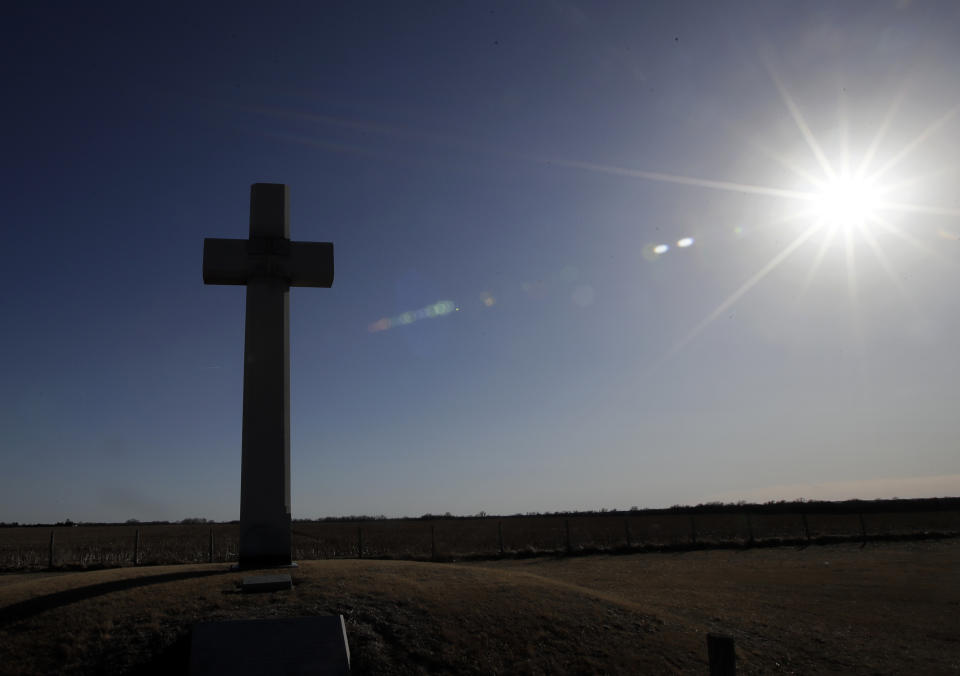 A cross, erected in memory of Fray Juan de Padilla, stands along US56 near Lyons, Kan., Tuesday, Feb. 12, 2019. The cross was a gift to the State of Kansas by the Knights of Columbus in 1950. (AP Photo/Orlin Wagner)