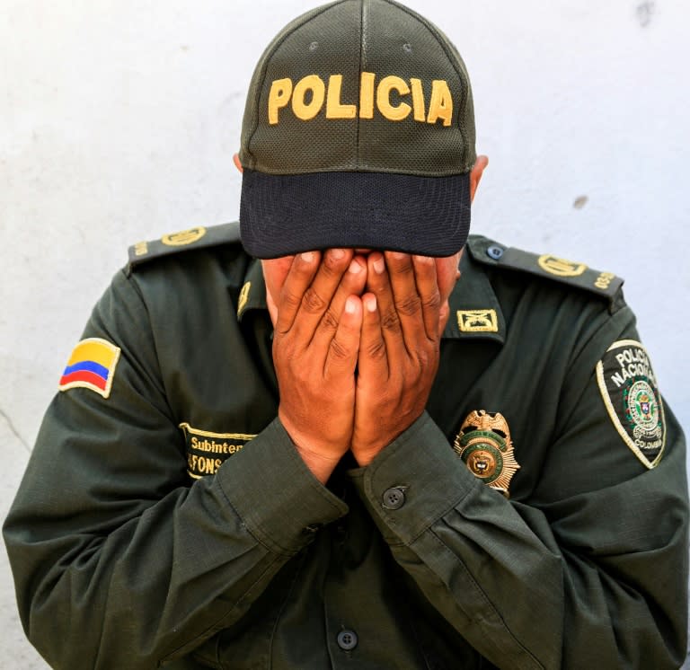 A Colombian police officer mourns during a vigil in tribute to the police killed in the attack in Barranquilla