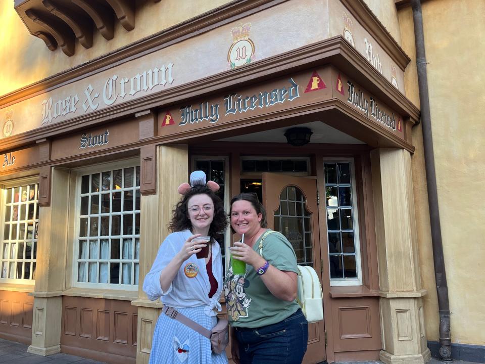 jenn and her friend posing in front of rose and crown pub at epcot