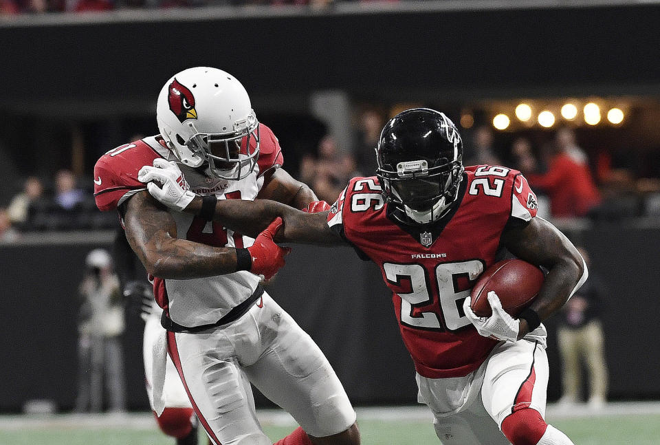 Atlanta Falcons running back Tevin Coleman (26) fends off Arizona Cardinals free safety Antoine Bethea (41) during the second half of an NFL football game, Sunday, Dec. 16, 2018, in Atlanta. (AP Photo/Danny Karnik)