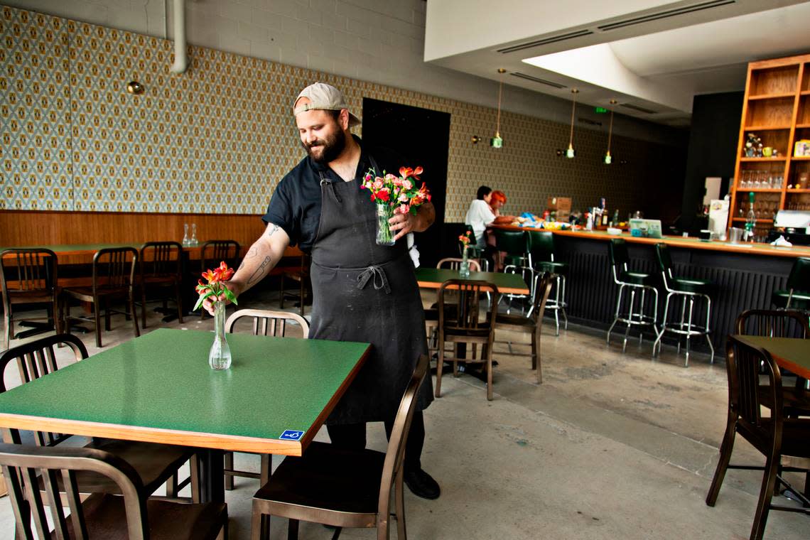 Chef Chris Lopez adds flowers to vases at Fine Folk restaurant in Raleigh on Wednesday afternoon, April 13, 2022.