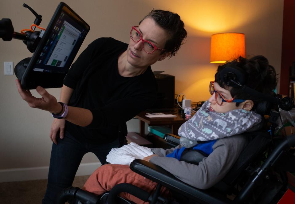 Kathleen Muldoon (left) works with her son, Gideon Dobson, in the living room of their Peoria, Ariz., home on Dec. 27, 2021.