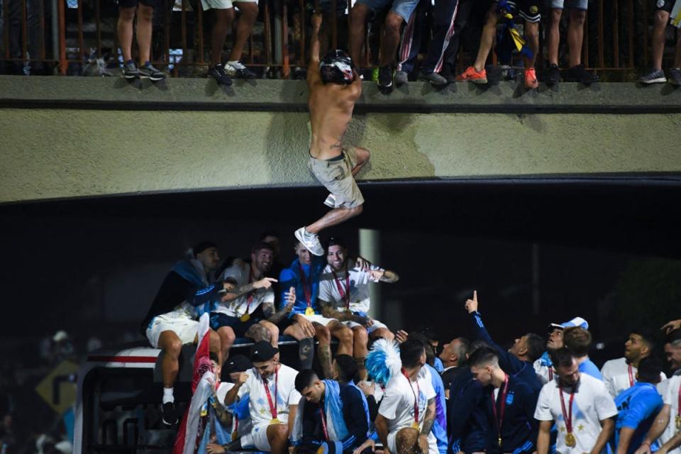 A fan jumps into the bus from an overhead bridge (Getty)