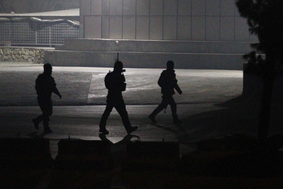 Afghan security officials take positions near the scene of attack (EPA)