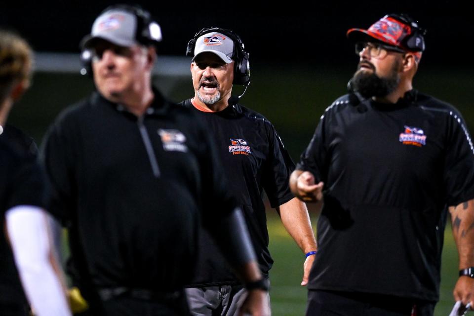 Charlotte's head coach Mike Sparks, center, communicates with players and coaches during the third quarter in the game against Olivet on Friday, Aug. 26, 2022, at Olivet High School.