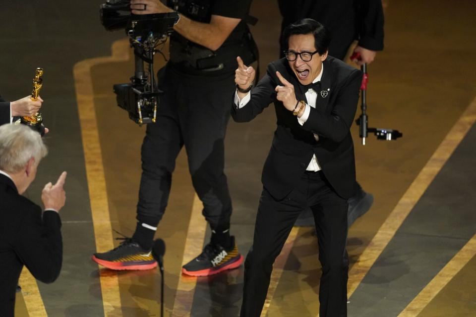 Two men in suits pointing at each other on a stage