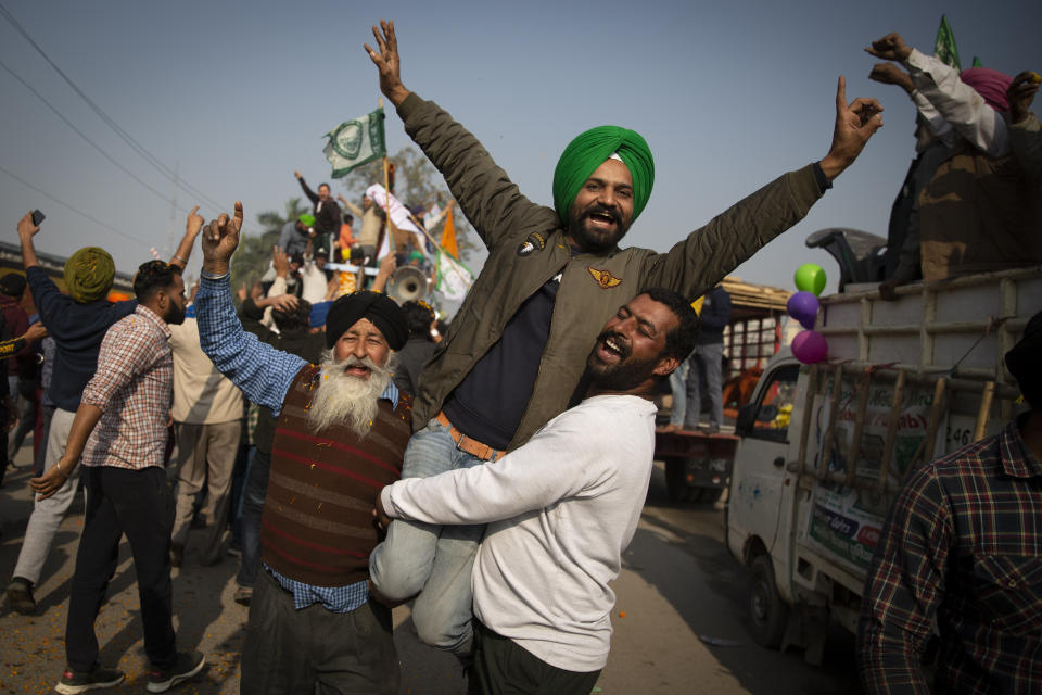Indian farmers celebrate while leaving the protest site in Singhu, on the outskirts of New Delhi, India, Saturday, Dec. 11, 2021. Tens of thousands of jubilant Indian farmers on Saturday cleared protest sites on the capital’s outskirts and began returning home, marking an end to their year-long demonstrations against agricultural reforms that were repealed by Prime Minister Narendra Modi's government in a rare retreat. (AP Photo/Altaf Qadri)