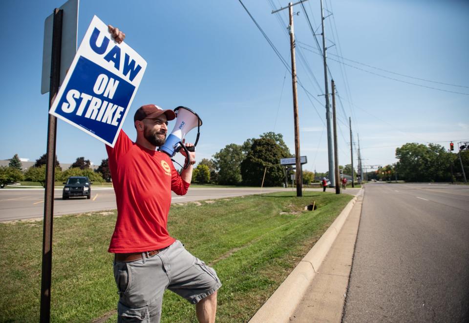 UAW Local 1753 member Jean Duchemin plays the song "Which Side Are You On?" thru a megaphone as he and fellow workers picket outside of the GM Lansing Redistribution Center, Friday, Sept. 22, 2023.