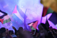 A demonstrator releases colored smoke as others wave Palestinian flags in a pro-Palestinian rally at the Felestin (Palestine) Sq. in Tehran, Iran, Friday, Oct. 20, 2023. (AP Photo/Vahid Salemi)