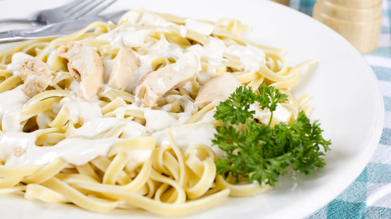 Chicken alfredo on plate with parsley