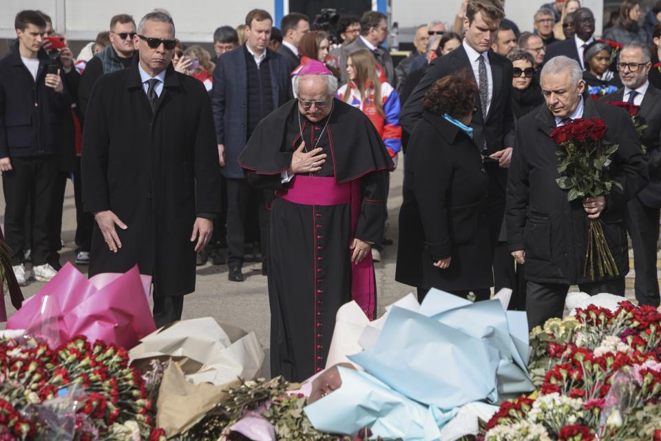 Giovanni d'Aniello, Apostolic Nuncio to the Russian Federation, center, and other ambassadors of foreign diplomatic missions attend a laying ceremony at a makeshift memorial in front of the Crocus City Hall on the western outskirts of Moscow, Russia, Saturday, March 30, 2024. (Sergei Ilnitsky/Pool Photo via AP)