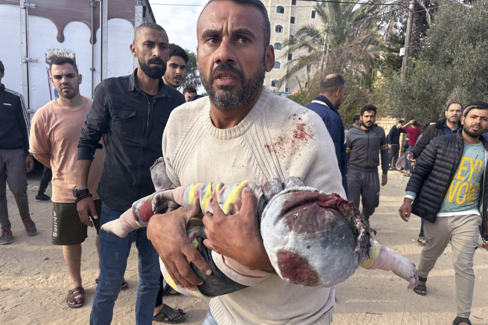 A Palestinian evacuates a wounded child after an Israeli strike on Al Zawayda, central Gaza Strip, Thursday, Dec. 28, 2023. (AP Photo/Mohammed Asad)