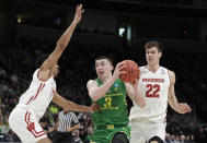 Oregon guard Payton Pritchard (3) drives between Wisconsin guard D'Mitrik Trice, left, and forward Ethan Happ (22) during the first half of a first-round game in the NCAA men’s college basketball tournament Friday, March 22, 2019, in San Jose, Calif. (AP Photo/Chris Carlson)