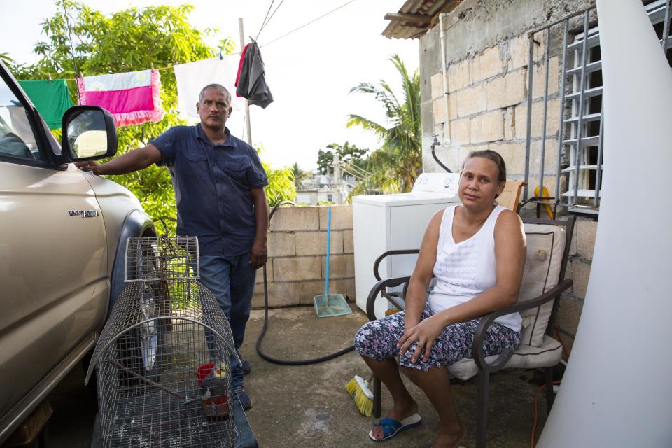 In August, Guerrero Herrera and his wife, Daysi Lantigua, sit on the front porch of their new cement home, which is just up the road from the wooden house they lost. (Photo: Carolina Moreno/HuffPost)