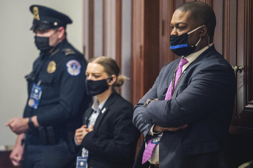 Capitol Police Officer Eugene Goodman, right, and other officers, watch never-before-seen security footage of rioters storming the Capitol on Jan. 6, during the second day of former President Donald Trump's second impeachment trial, Wednesday, Feb. 10, 2021 in the Capitol in Washington. (Brandon Bell/The New York Times via AP, Pool)