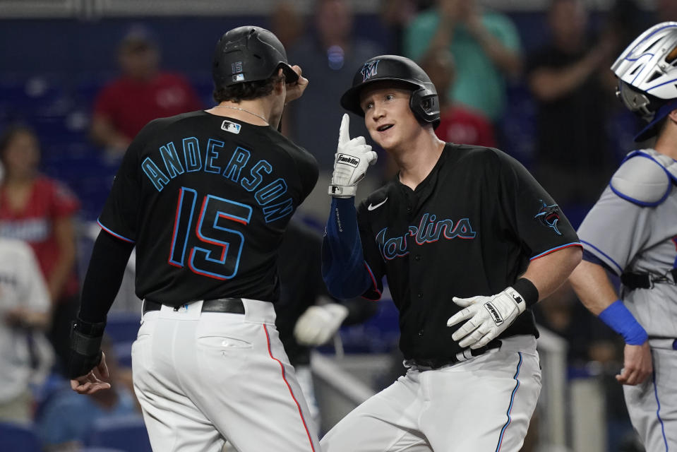 Miami Marlins' Garrett Cooper gestures to Brian Anderson (15) after hitting a two-run home run during the first inning of a baseball game against the New York Mets, Friday, Sept. 9, 2022, in Miami. (AP Photo/Marta Lavandier)