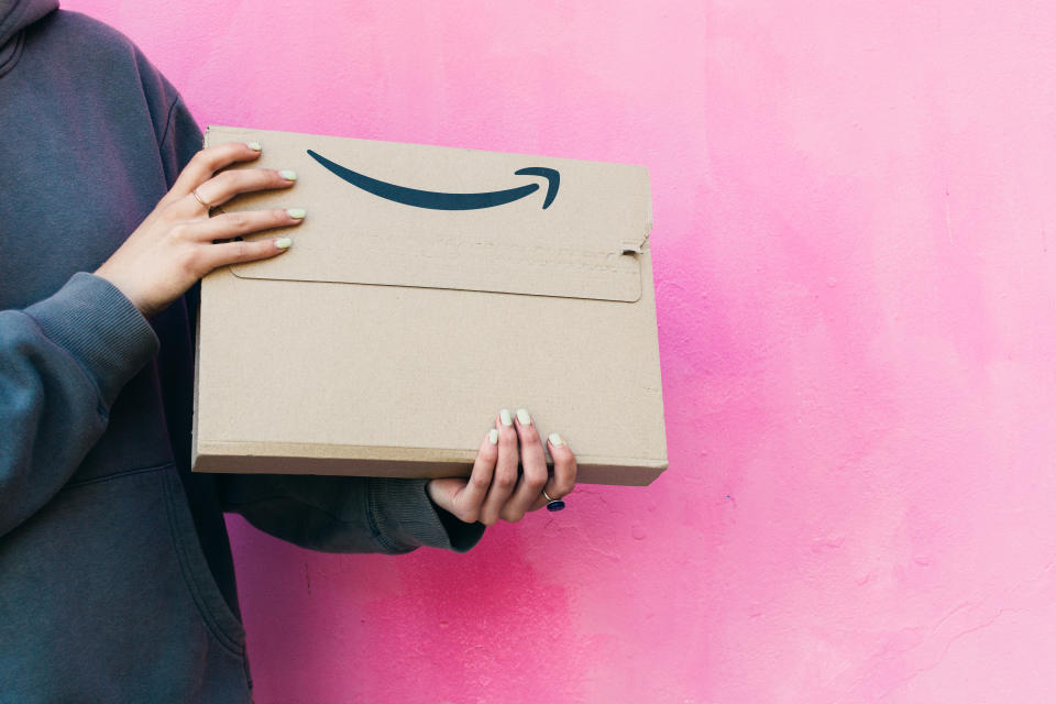 Frau hält einen Karton von Amazon Prime in der Hand