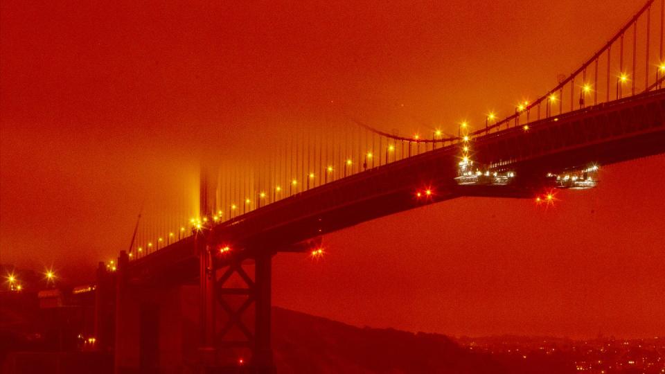 Die Golden Gate Bridge ist in orangefarbenem Licht durch die anhaltenden Waldbrände zu sehen.