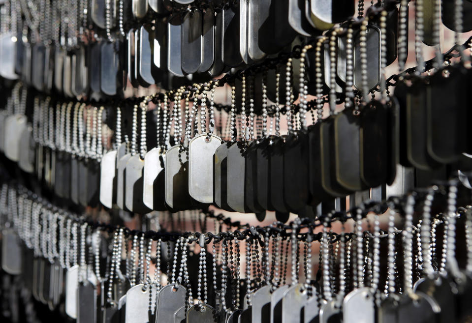 In this Wednesday, Nov. 7, 2018 photo, blank military dog tags hang in a memorial honoring fallen soldiers from the conflicts in Iraq and Afghanistan, on the grounds of Old North Church, in Boston. Since 2005, thousands of military dog tags have hung like wind chimes outside the church in touching tribute to American forces killed in Iraq and Afghanistan. The new plaque and wreath will explain the meaning of the dog tags and acknowledge Britain’s contribution and sacrifice. (AP Photo/Steven Senne)