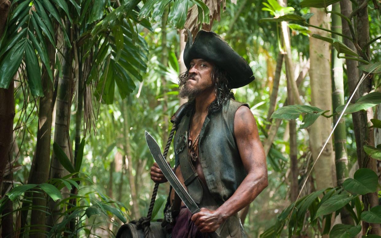 The late surfer in costume and make-up for Pirates of the Caribbean, holding a large prop knife
