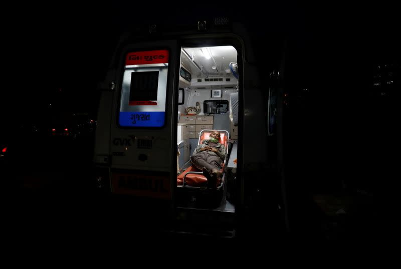 A patient lies inside an ambulance waiting in a queue to enter a COVID-19 hospital in Ahmedabad