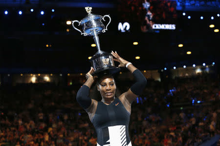 Serena Williams places her trophy on her head after winning her Women's singles final match against Venus Williams. REUTERS/Issei Kato