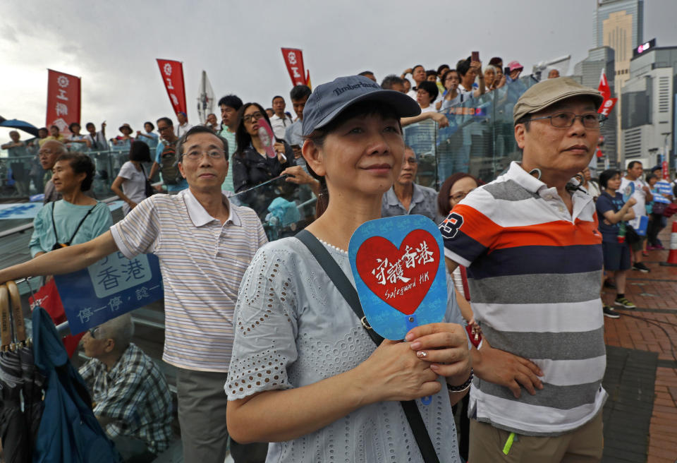 A woman holds a fan reads "Safeguard Hong Kong" during a counter-rally in support of the police in Hong Kong Saturday, July 20, 2019. Police in Hong Kong have raided a homemade-explosives manufacturing lab ahead of another weekend of protests in the semi-autonomous Chinese territory. (AP Photo/Vincent Yu)