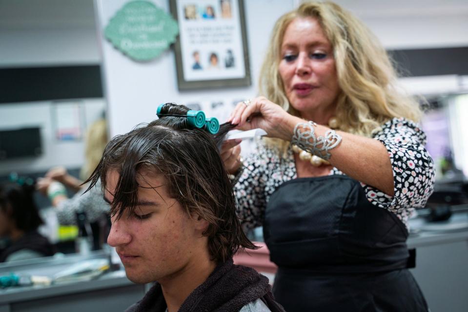 Jacob Terechenok, 16, of Canton, has his hair permed for the first time by hairstylist Nikki Elias-Porter, 68, of Dearborn, at Anthony's Hair Inc in Allen Park on July 25, 2023. "My brother had one, so it kind of influenced me a little," said Terechenok. "It's just something new for me to try because I've always had straight hair."