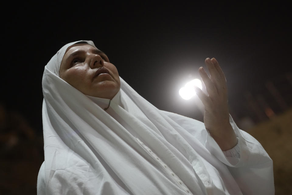 An Iranian pilgrim prays on the rocky hill known as the Mountain of Mercy, on the Plain of Arafat, during the annual Hajj pilgrimage, near the holy city of Mecca, Saudi Arabia, Tuesday, June 27, 2023. Around two million pilgrims are converging on Saudi Arabia's holy city of Mecca for the largest Hajj since the coronavirus pandemic severely curtailed access to one of Islam's five pillars. (AP Photo/Amr Nabil)