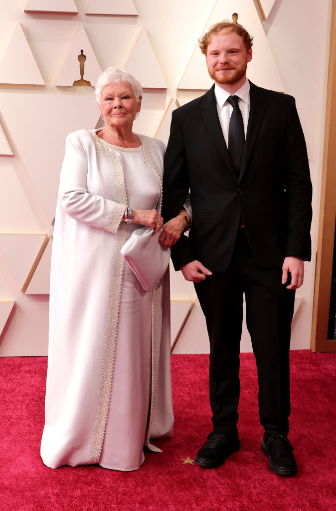 Dame Judi looked chic in a Dolce and Gabbana dress and jacket combo, pictured with her grandson Sam Williams. (Getty Images)