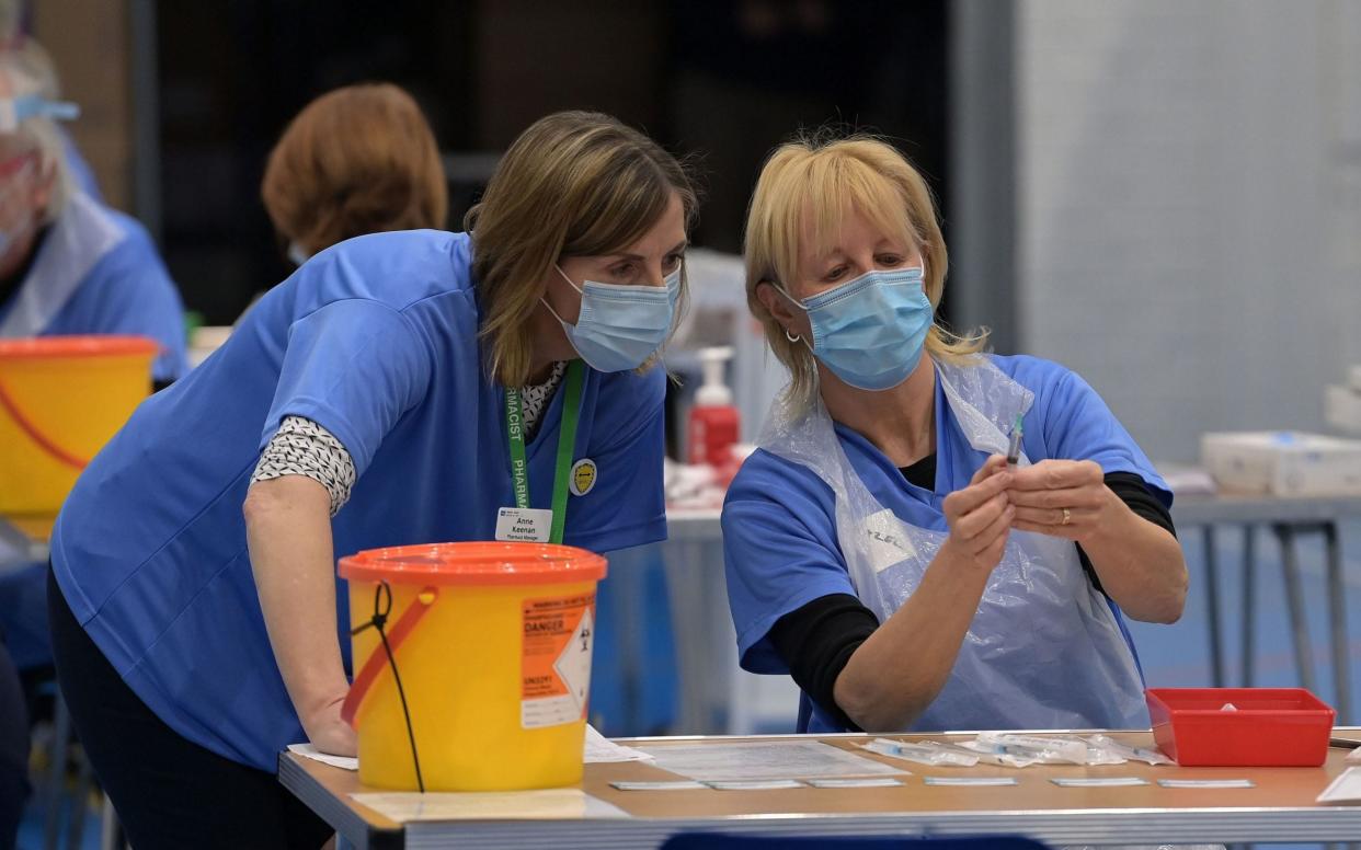Nurses prepare vaccine jabs at the Lakeland Forum vaccination centre in Enniskillen, Northern Ireland - PA