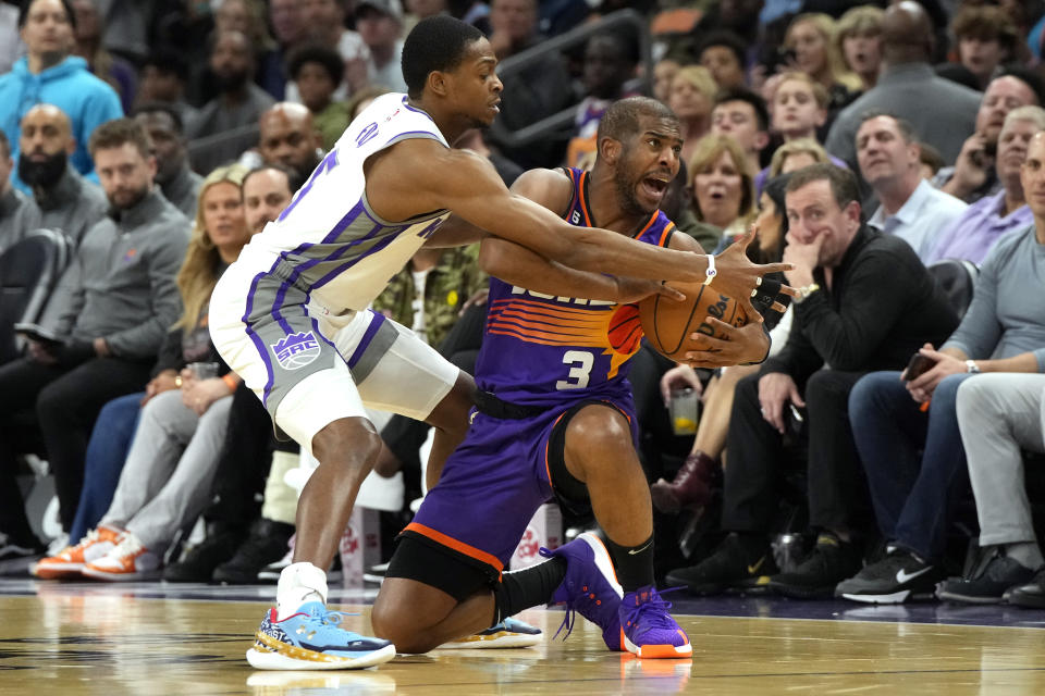 Sacramento Kings guard De'Aaron Fox (5) pressures Phoenix Suns guard Chris Paul (3) during the first half of an NBA basketball game, Saturday, March 11, 2023, in Phoenix. (AP Photo/Rick Scuteri)