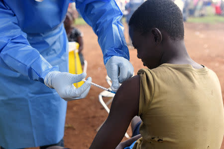A Congolese health worker administers Ebola vaccine to a boy who had contact with an Ebola sufferer in the village of Mangina in North Kivu province of the Democratic Republic of Congo, August 18, 2018. REUTERS/Olivia Acland/Files