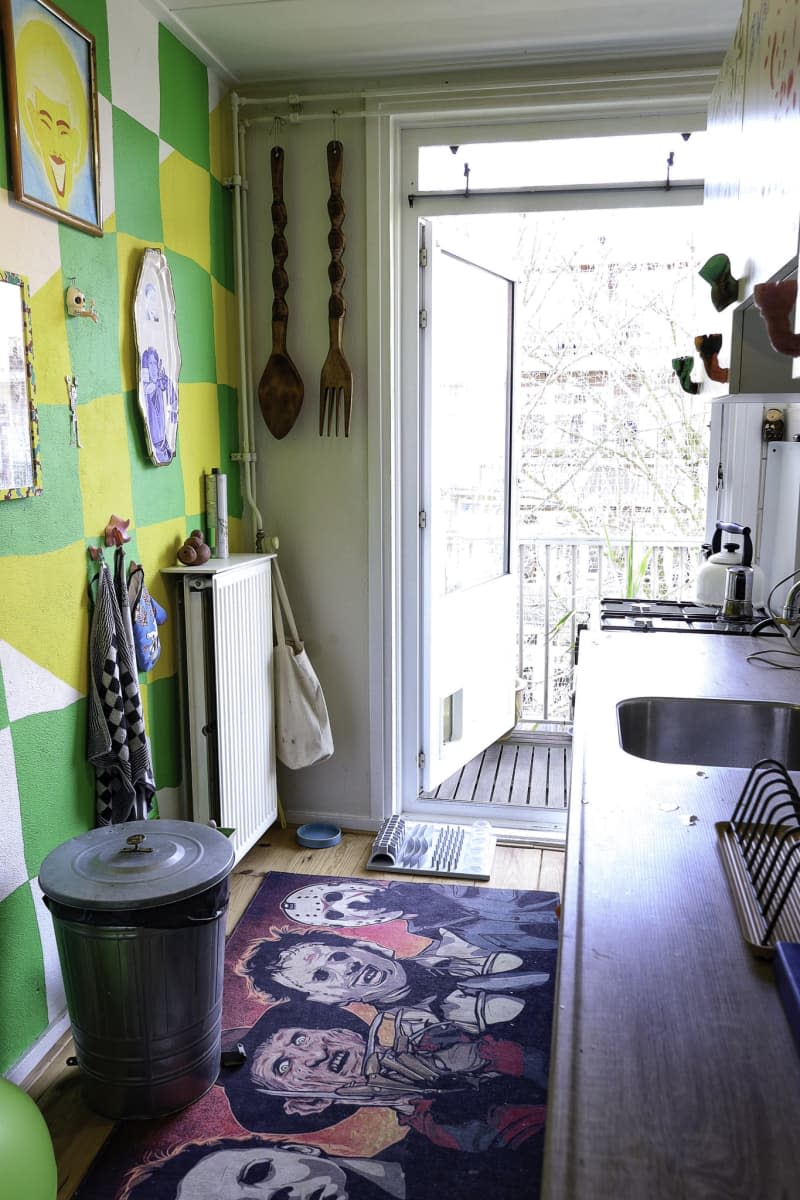 kitchen with one green and yellow checked wall and door open to sunny porch