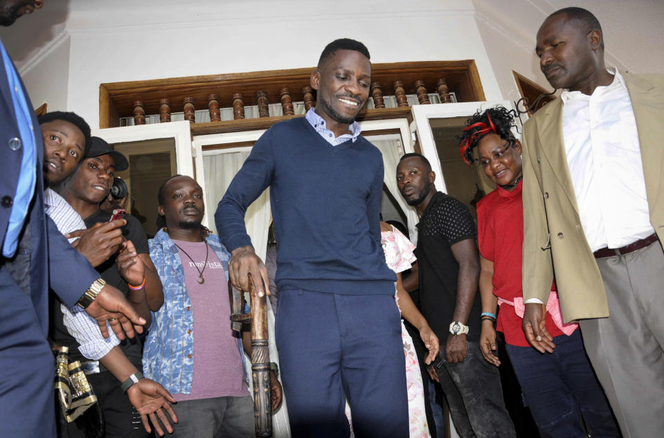 Pop star-turned-opposition lawmaker Bobi Wine, whose real name is Kyagulanyi Ssentamu, walks with a cane as he goes to greet supporters at his home in Kampala, Uganda Thursday, Sept. 20, 2018. Wine vowed Thursday to continue his fight for more freedom in the country "or we shall die trying," shortly after security forces took him into custody on his arrival from the United States after treatment for alleged torture. (AP Photo/Ronald Kabuubi)