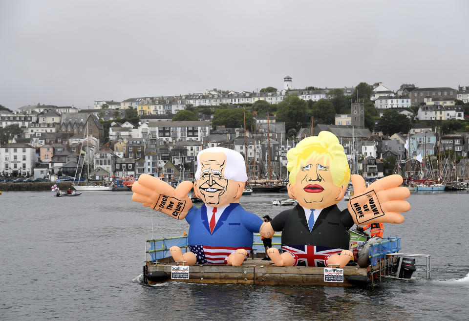 Two giant balloons depicting U.S. President Joe Biden, left, and British Prime Minister Boris Johnson float on a dock during a 'crack the crisis' action by NGO's in the harbour of Falmouth, Cornwall, England, during an action by NGO's on Friday, June 11, 2021. Leaders of the G7 begin their first of three days of meetings on Friday in Carbis Bay, in which they will discuss COVID-19, climate, foreign policy and the economy. (AP Photo/Alberto Pezzali)