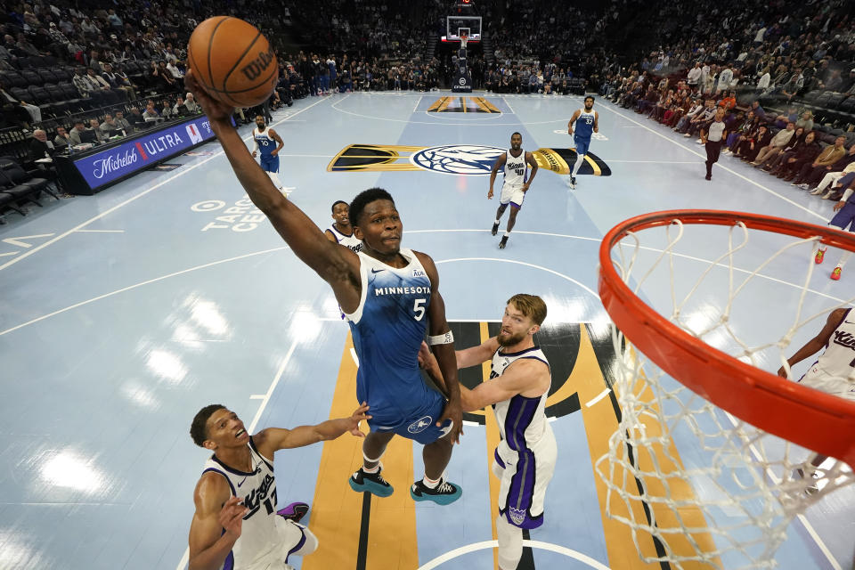 Minnesota Timberwolves guard Anthony Edwards (5) attempts a dunk as Sacramento Kings forwards Kessler Edwards, left, and Domantas Sabonis, right, defend during the second half of an NBA basketball In-Season Tournament game, Friday, Nov. 24, 2023, in Minneapolis. (AP Photo/Abbie Parr)