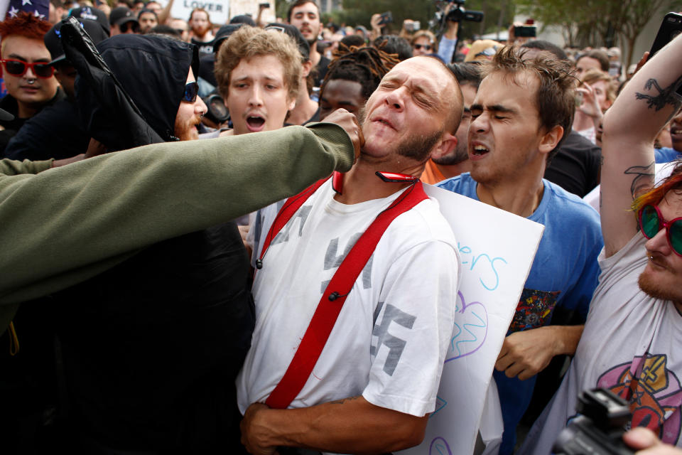 A man wearing a shirt with Nazi swastikas on it is punched by an unidentified member of the crowd near where white supremacist Richard Spencer spoke on Thursday at the University of Florida in Gainesville. (Photo: Brian Blanco via Getty Images)