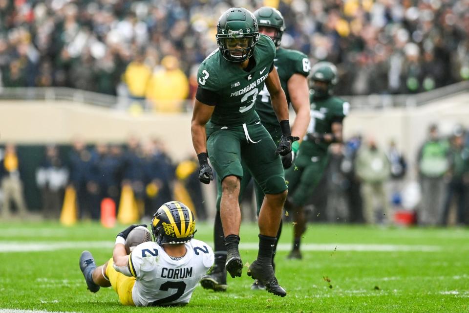 Michigan State's Xavier Henderson, right, celebrates after tackling Michigan's Blake Brad Hawkins during the fourth quarter on Saturday, Oct. 30, 2021, at Spartan Stadium in East Lansing.