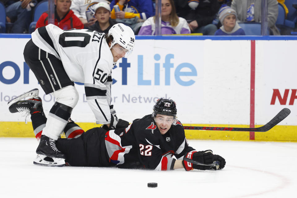 Buffalo Sabres right wing Jack Quinn (22) is brought down by Los Angeles Kings defenseman Sean Durzi (50) during the first period of an NHL hockey game, Tuesday, Dec. 13, 2022, in Buffalo, N.Y. (AP Photo/Jeffrey T. Barnes)