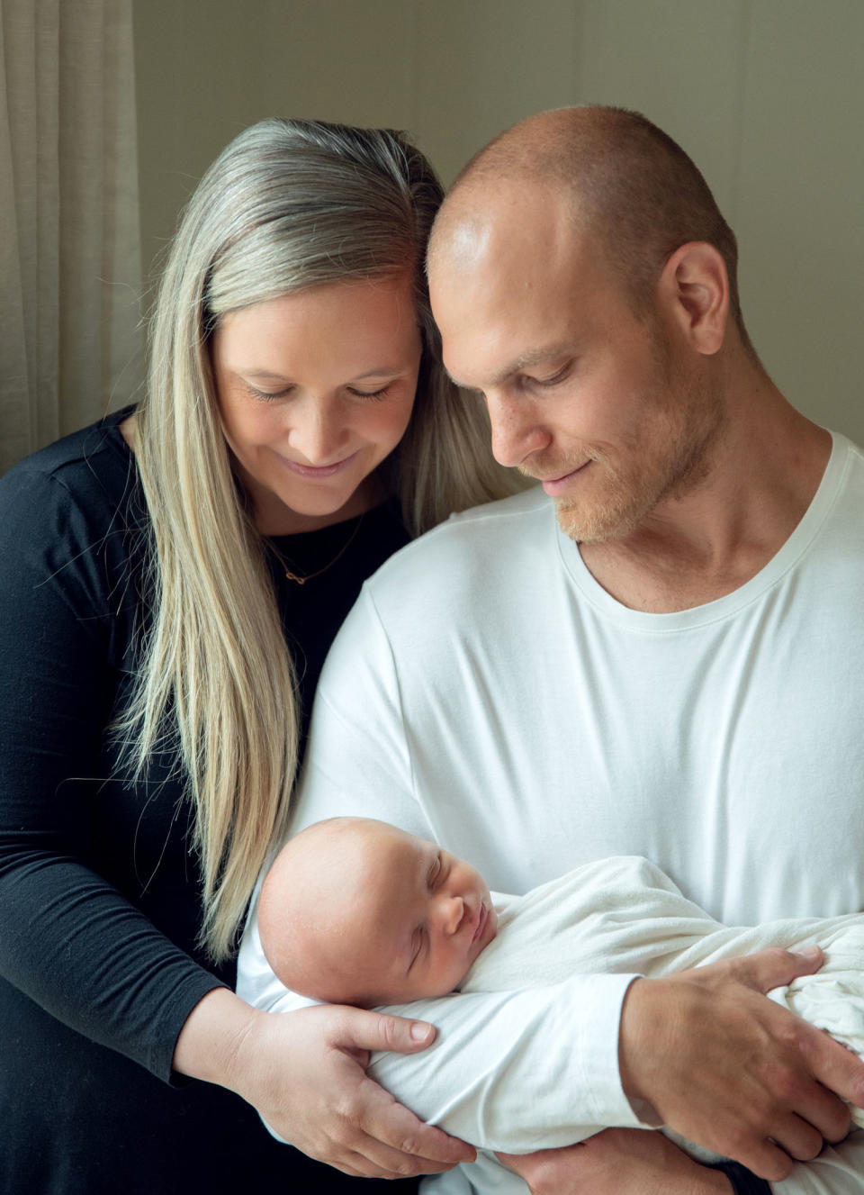 Image: Kate and Brandon Movitz hold their newborn, Pierce, in 2020. (Andrea Peardon Photography)