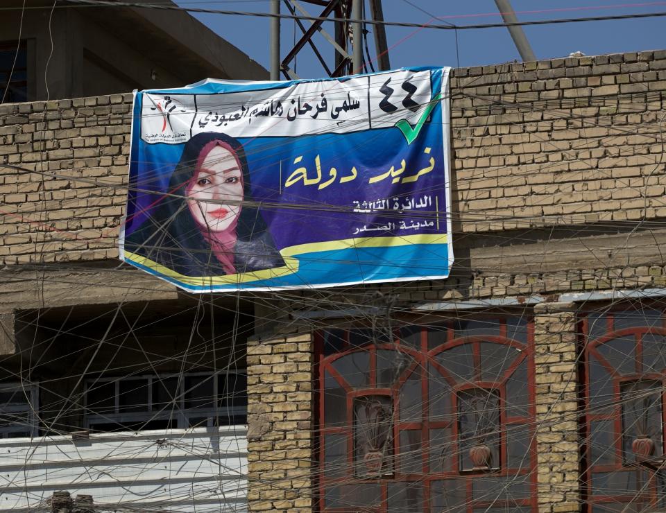 A campaign poster for upcoming early parliamentary elections is hanging behind a private generator network wires in Baghdad, Iraq, Monday, Sept. 20, 2021. In Iraq, electricity is a potent symbol of endemic corruption, rooted in the country’s sectarian power-sharing system. It’s perpetuated after each election cycle: Once results are tallied, politicians jockey for appointments in a flurry of negotiations based on the number of seats won. (AP Photo/Hadi Mizban)