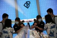 A staff member wearing a face mask attends to customers at a Chinese cosmetics brand Perfect Diary store, following the coronavirus disease (COVID-19) outbreak in Beijing