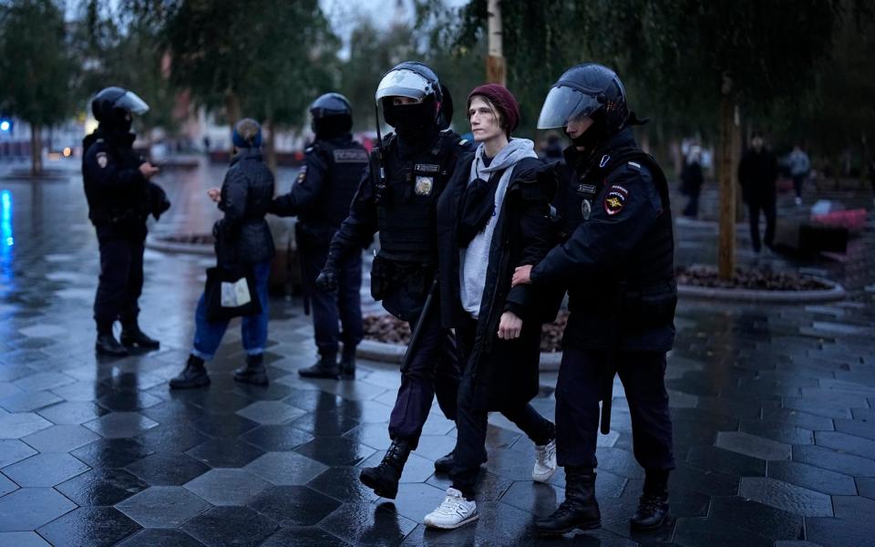 Police officers detain a demonstrator during a protest against a partial mobilization in Moscow, Russia, Saturday, Sept. 24, 2022. (AP Photo)  - AP Photo