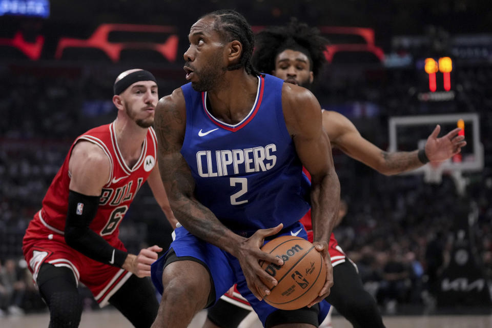 Los Angeles Clippers forward Kawhi Leonard (2) is defended by Chicago Bulls guards Alex Caruso, left, and guard Coby White, back right, during the first half of an NBA basketball game in Los Angeles, Saturday, March 9, 2024. (AP Photo/Eric Thayer)