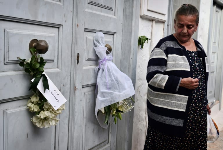 A former neighbour looks at flowers placed outside the summer house of late Canadian singer-songwriter and poet Leonard Cohen on the Greek island of Hydra, on November 12, 2016