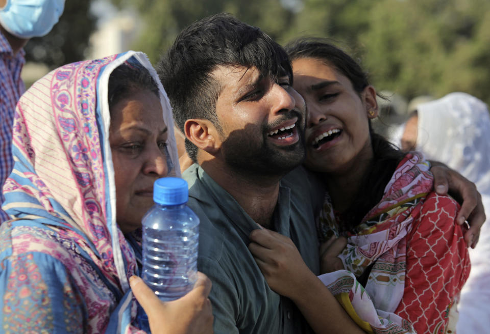 Family members and relatives of Simon Eric, who died in the crash of a state-run Pakistan International Airlines plane on Friday, mourn during his funeral in Karachi, Pakistan, Monday, May 25, 2020. (AP Photo/Fareed Khan)